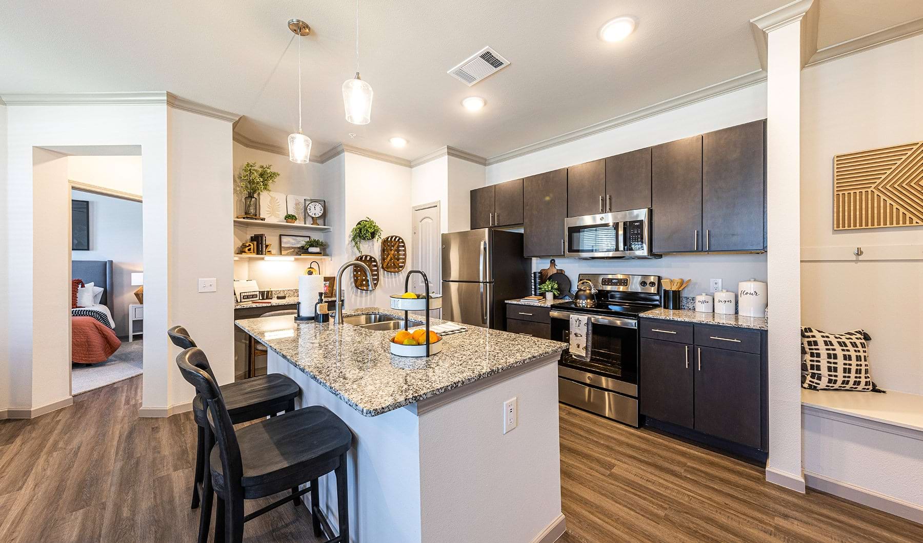 Kitchen Spacious and well lit kitchen with wood floors and stainless steel appliances