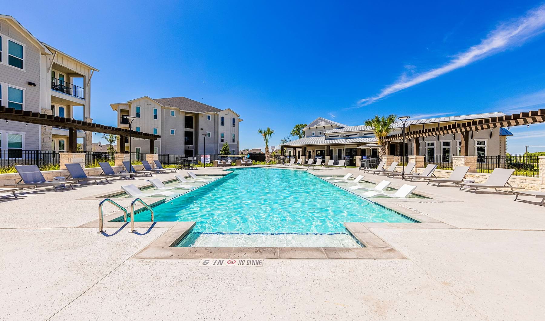 Swimming Pool Large sparkling blue pool with a large deck and lounge chairs